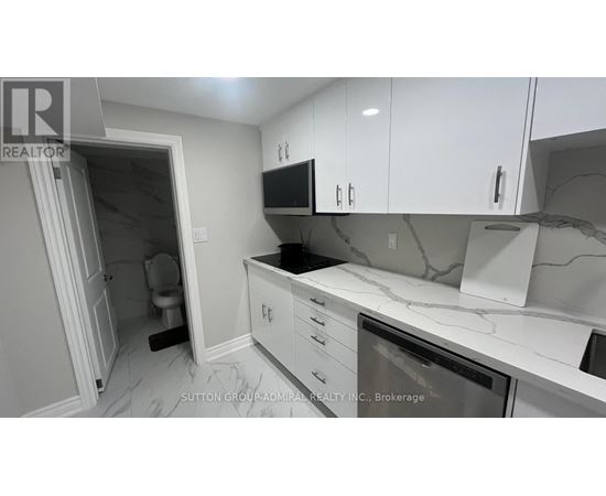 A kitchen with white cabinets and a marble countertop.