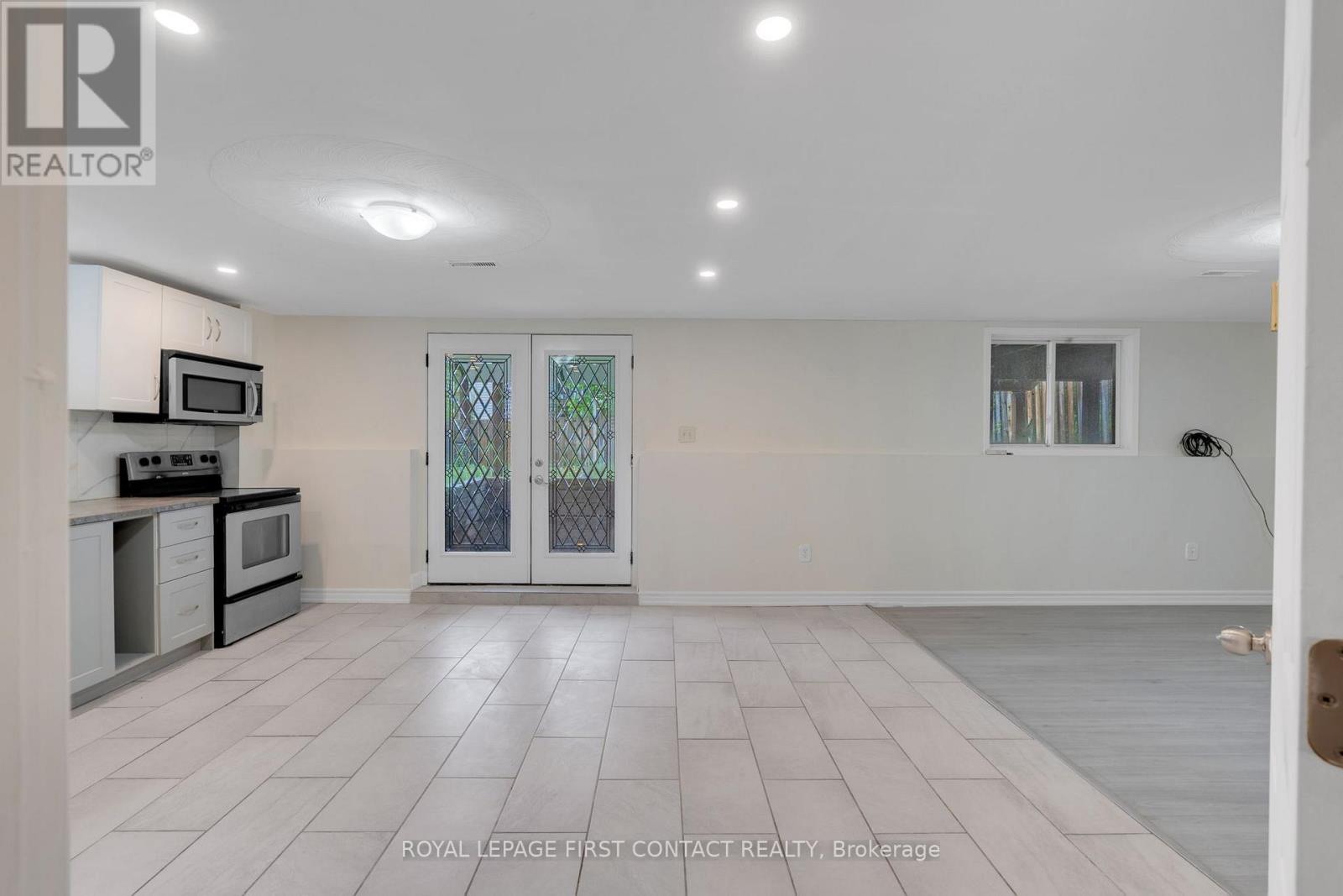 A spacious kitchen with white cabinets and a microwave above the stove.