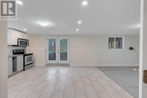 A spacious kitchen with white cabinets and a microwave above the stove.