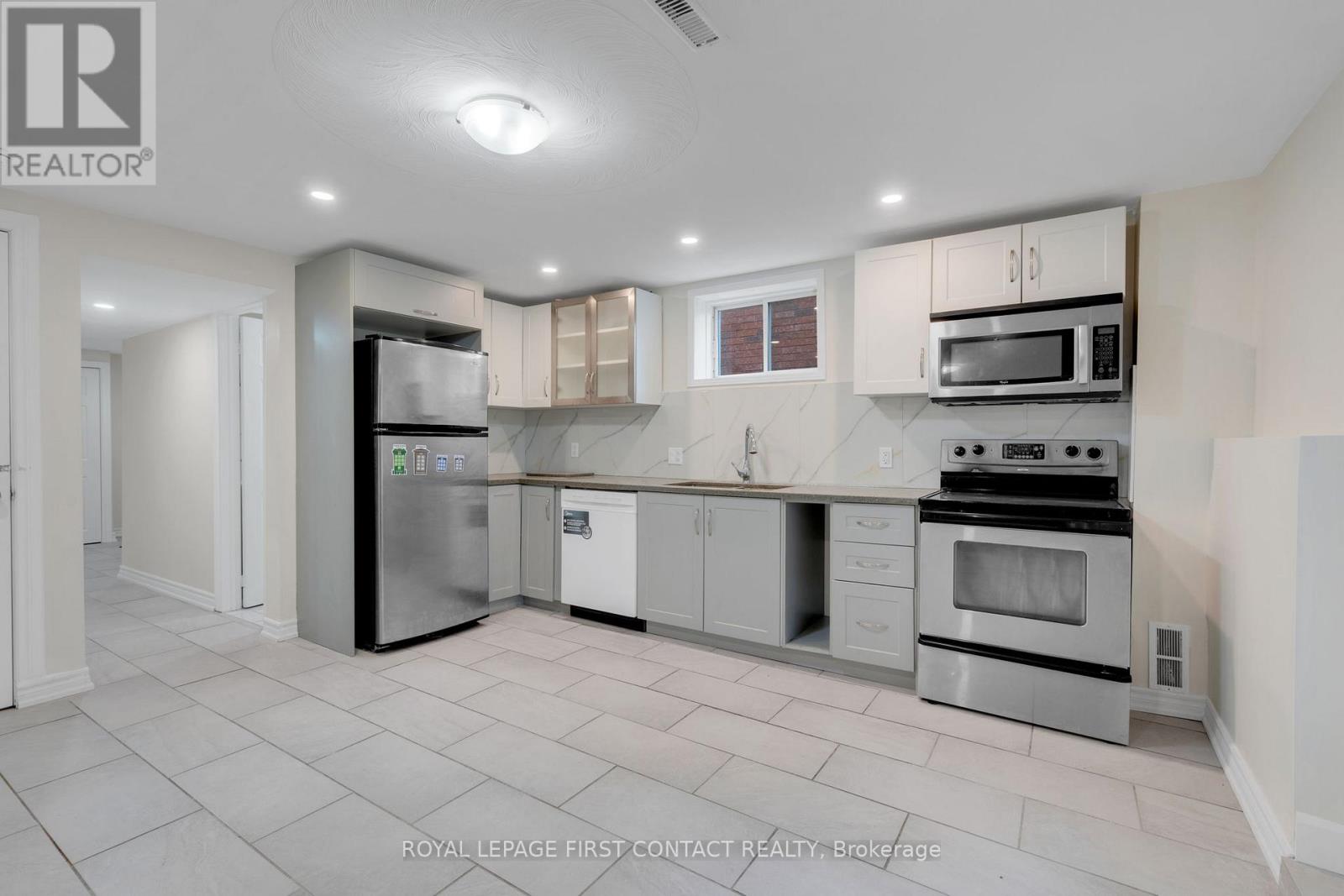 A kitchen with white cabinets and appliances is on the market.