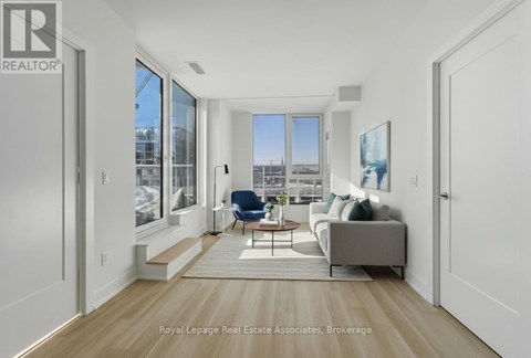 A living room with a couch, chair, and a view of the city.