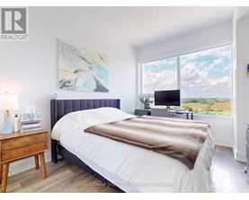 A bedroom with a large bed and a painting on the wall.