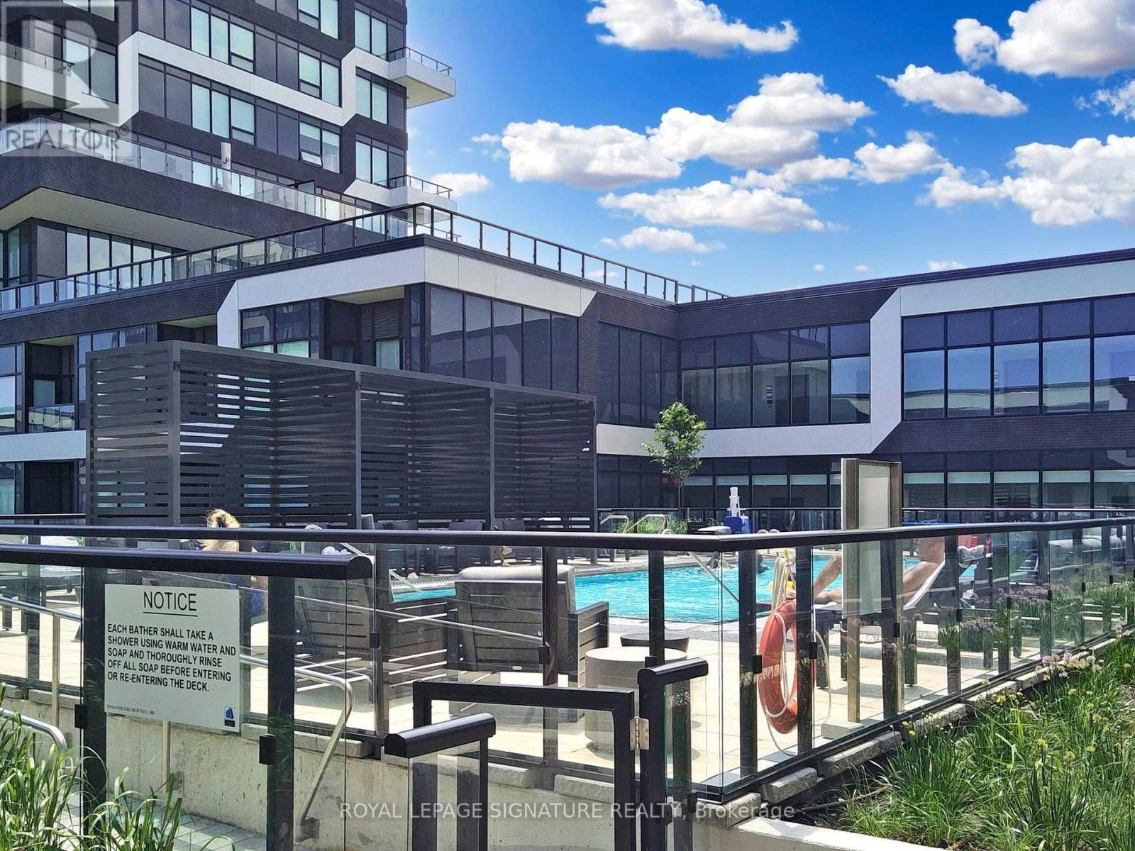 A pool area with a notice sign on the fence.