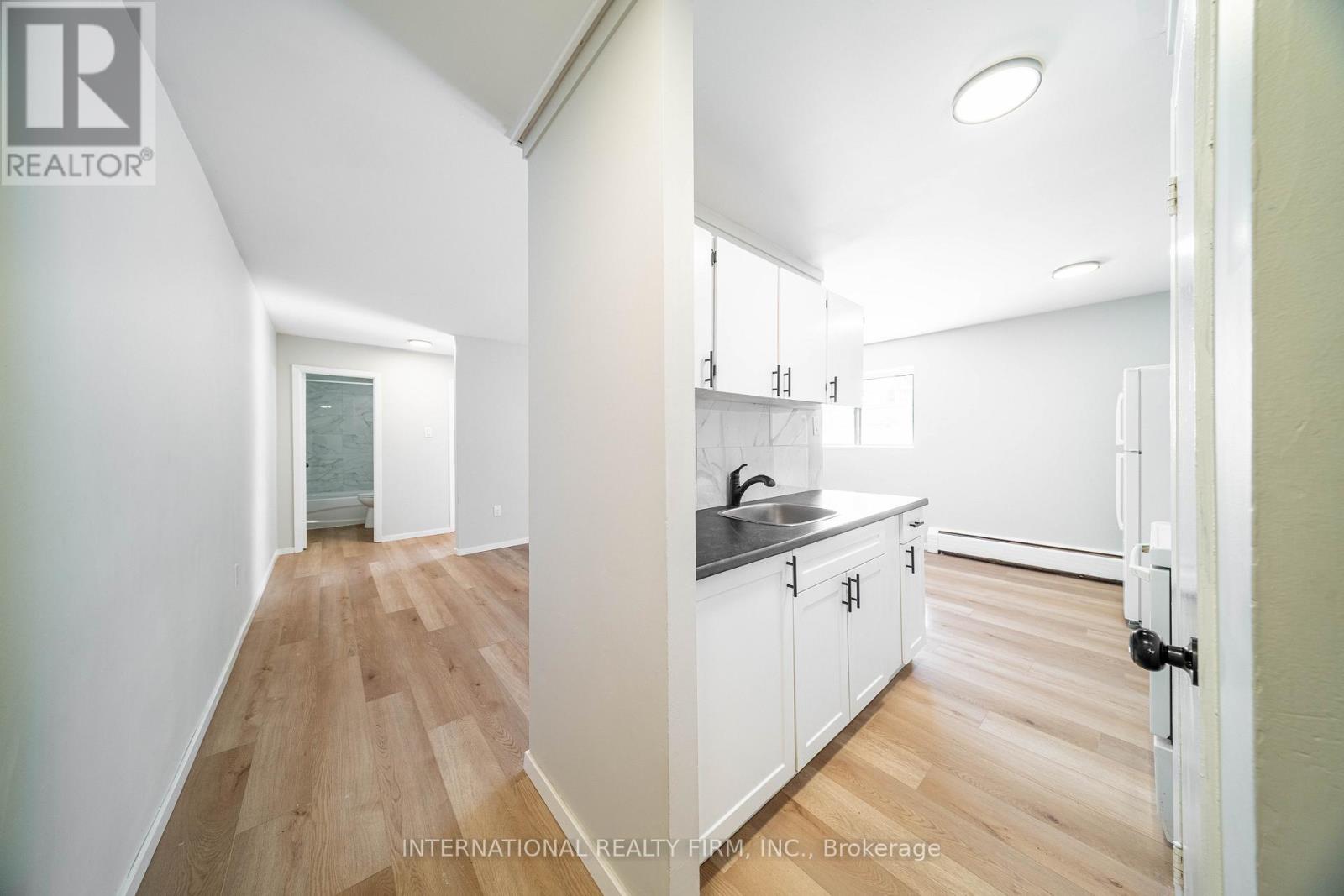 A white kitchen with a sink and cabinets.