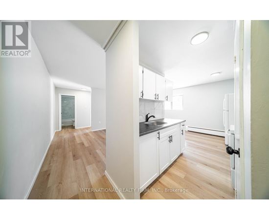 A white kitchen with a sink and cabinets.