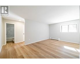 A room with wooden flooring and white walls.