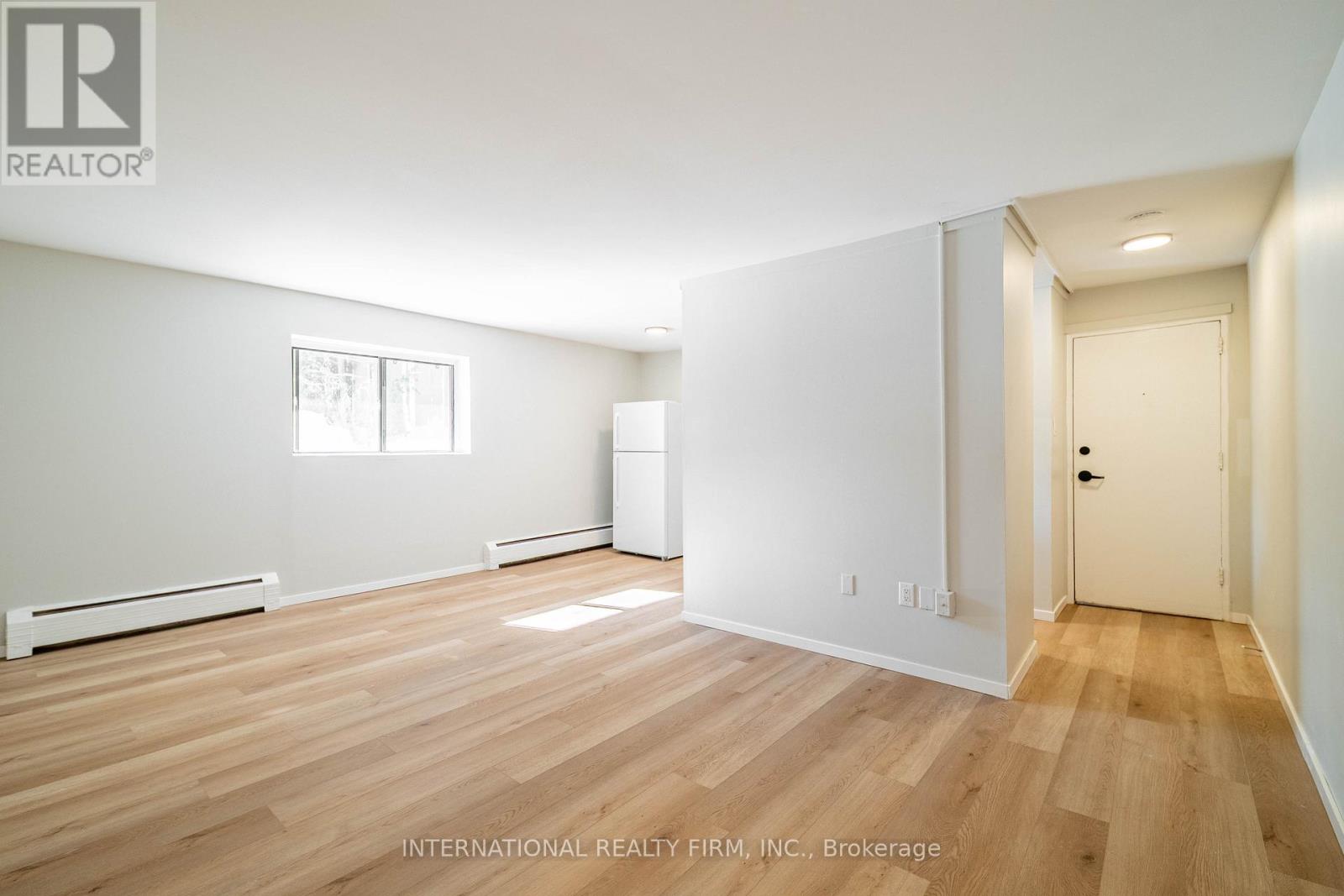 A room with wooden flooring and white walls.