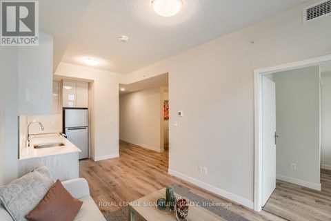 A living room with a couch and a kitchen area in the background.