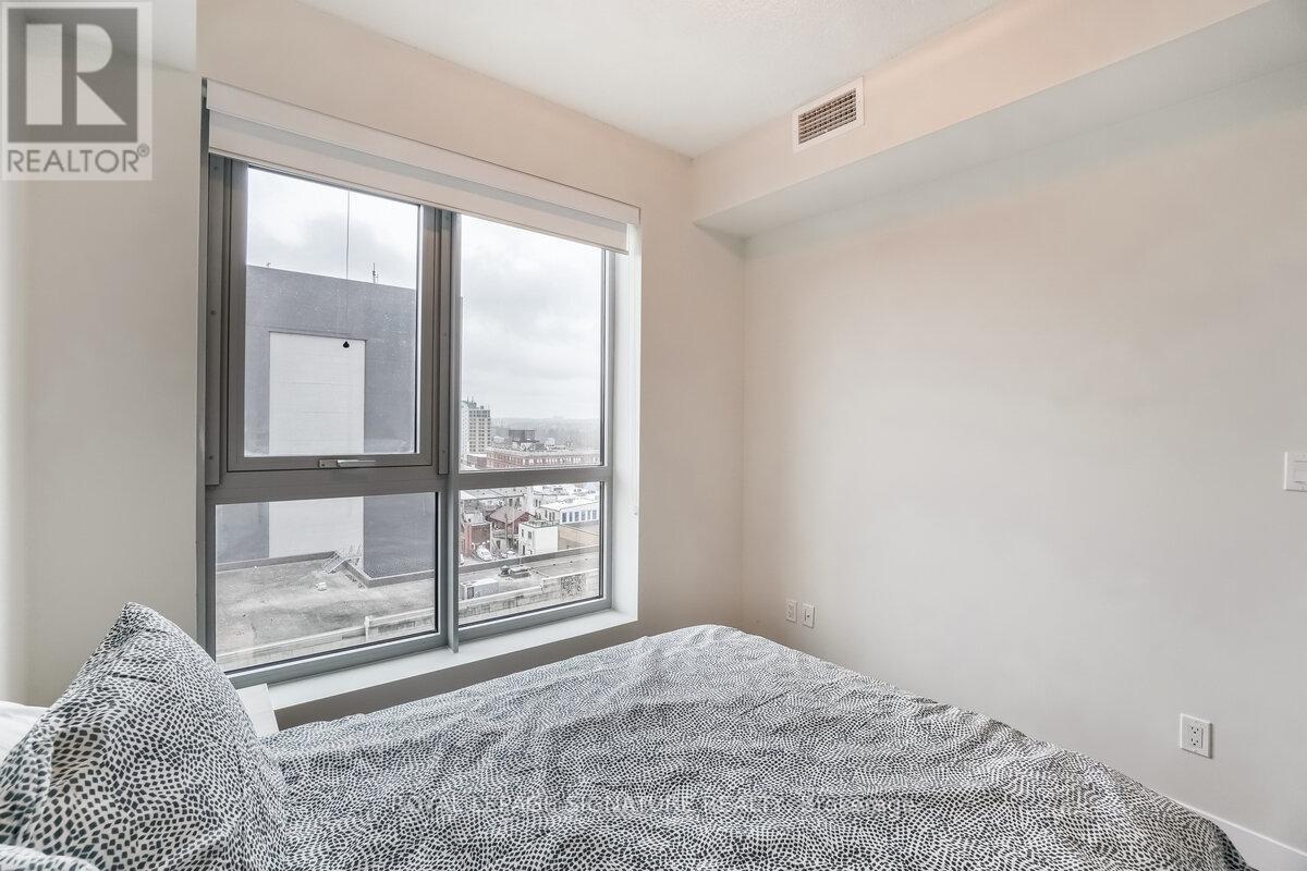 A bedroom with a large bed and a window overlooking a cityscape.