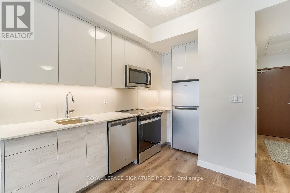 A kitchen with white cabinets and a wooden floor.