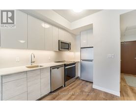 A kitchen with white cabinets and a wooden floor.