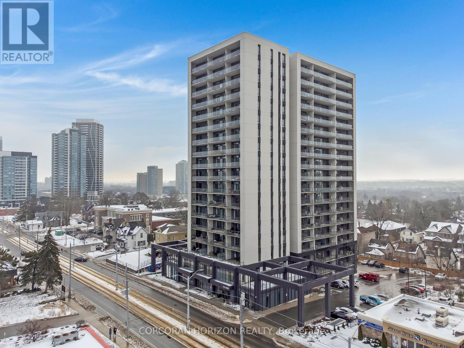 A tall building with a lot of windows is in the foreground with a city in the background.