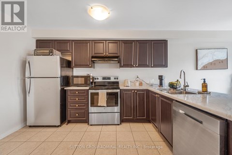 A kitchen with brown cabinets and a white refrigerator.