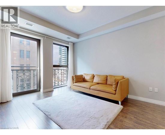 A living room with a tan couch and a white rug.