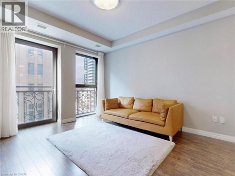A living room with a tan couch and a white rug.