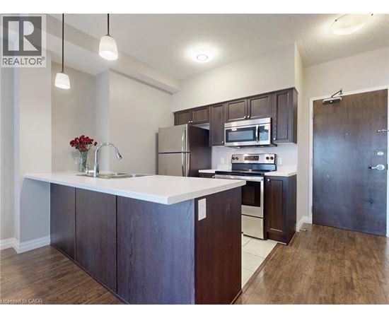 A kitchen with dark wood cabinets and stainless steel appliances.