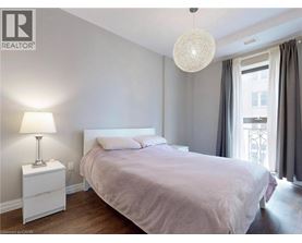 A bedroom with a bed, nightstand, and lamp.