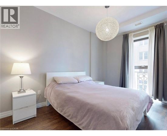 A bedroom with a bed, nightstand, and lamp.