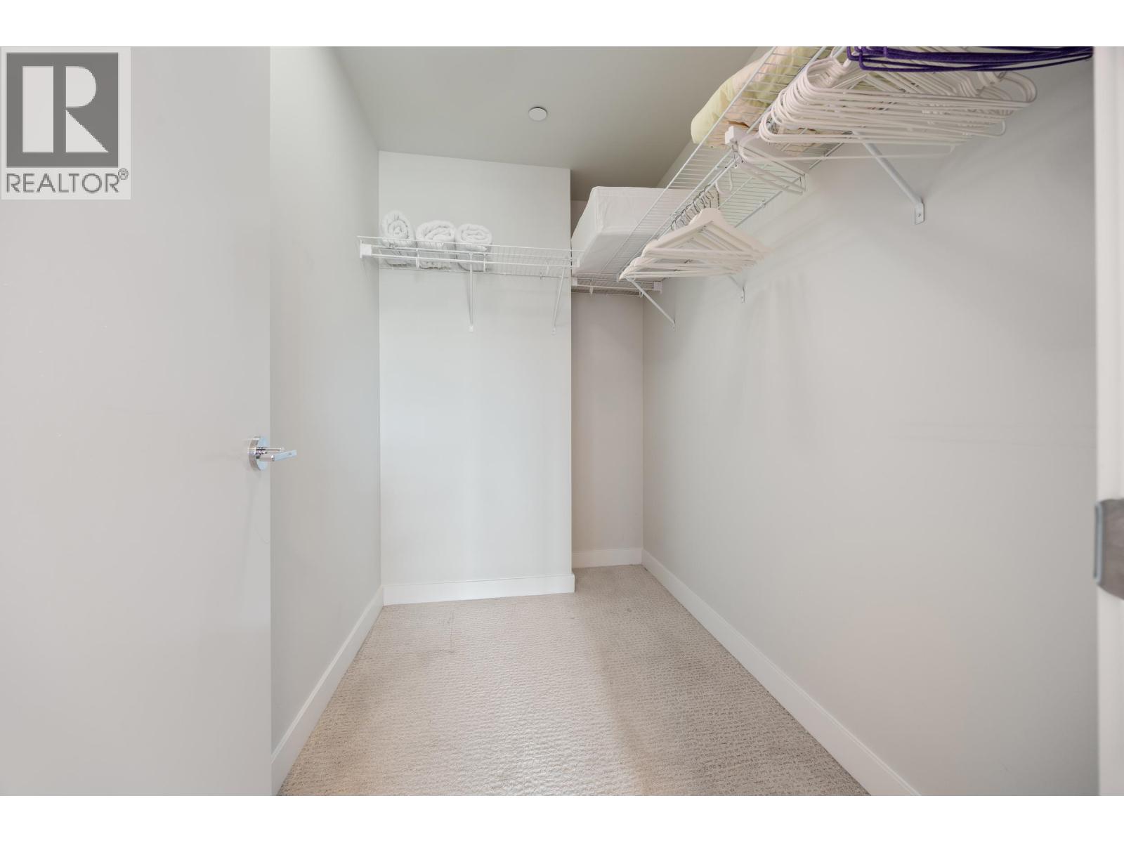 A white bedroom with a bed on the left and a closet on the right.