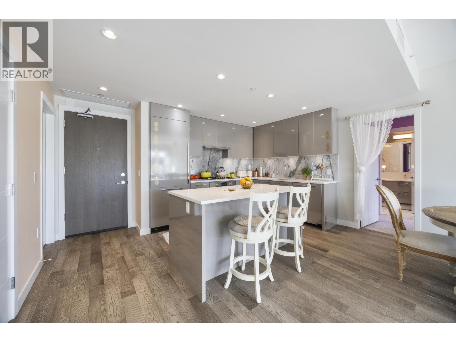 A modern kitchen with a dining table and chairs.