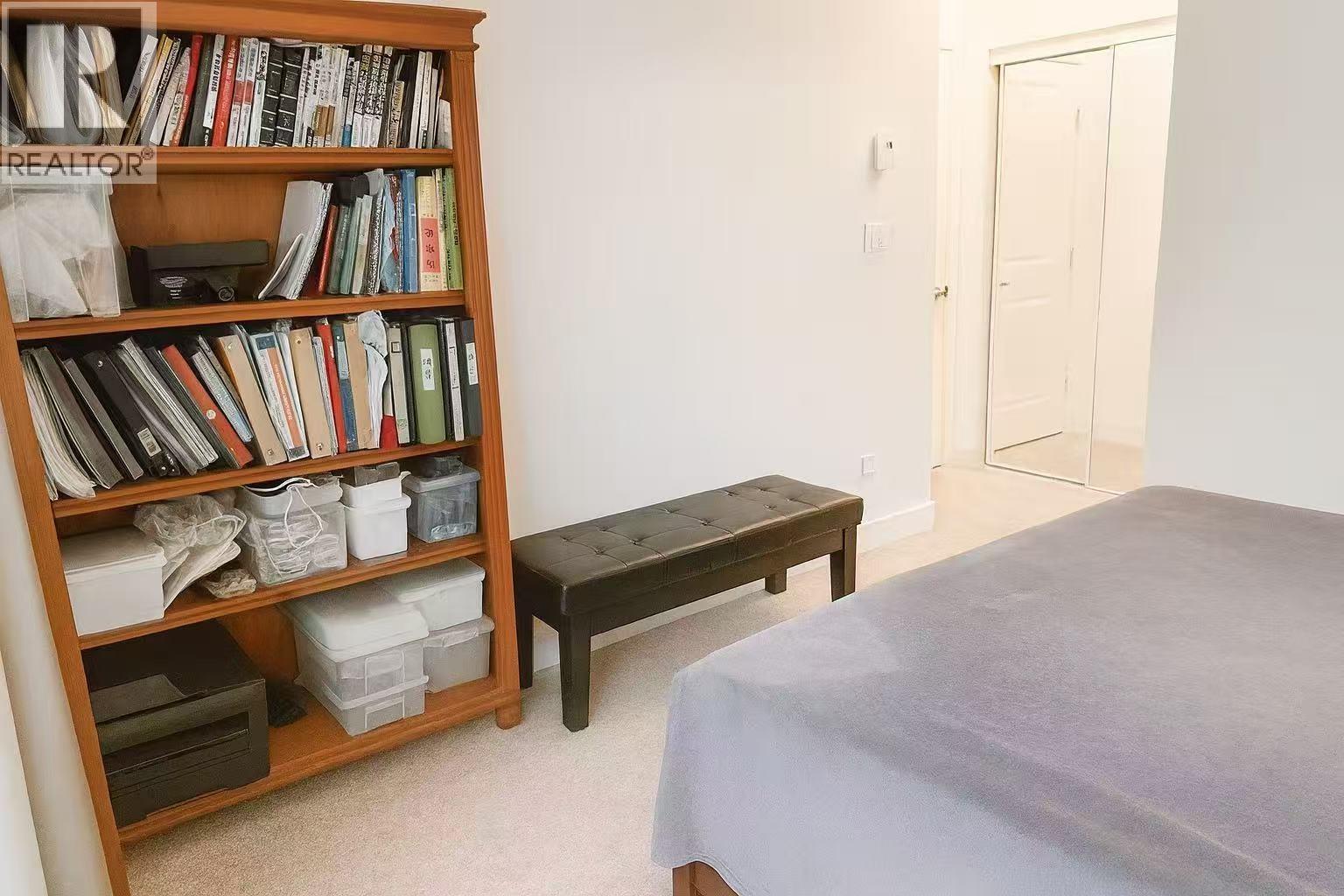 A bedroom with a bed, a bookshelf, and a bench.