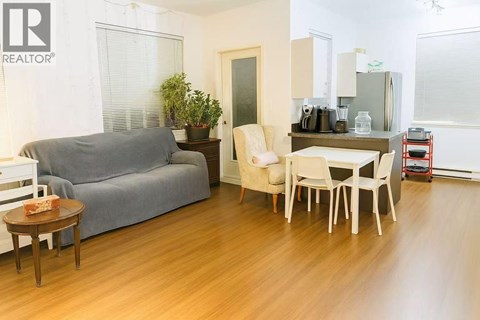 A living room with a grey couch, a white chair, and a wooden coffee table.