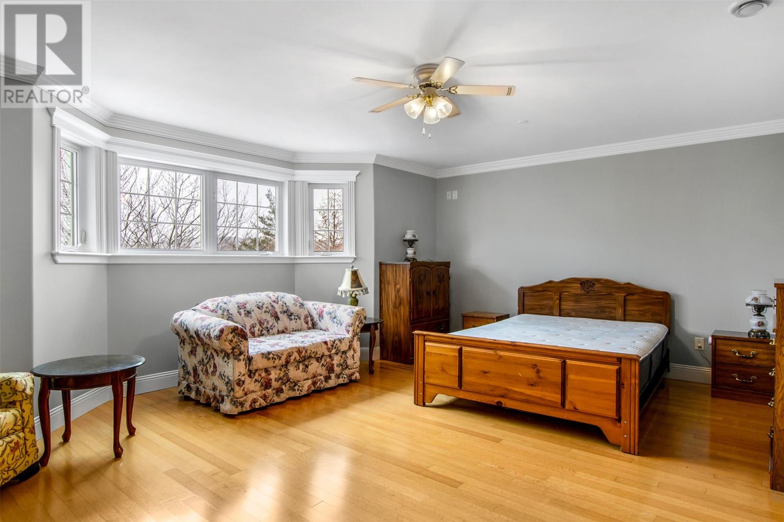 A bedroom with a bed, dresser, and chair.