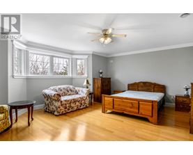 A bedroom with a bed, dresser, and chair.