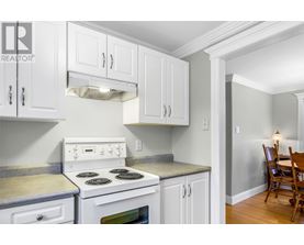 A white stove and oven in a kitchen with white cabinets.