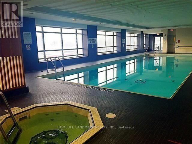A large indoor swimming pool with a smaller hot tub in front.