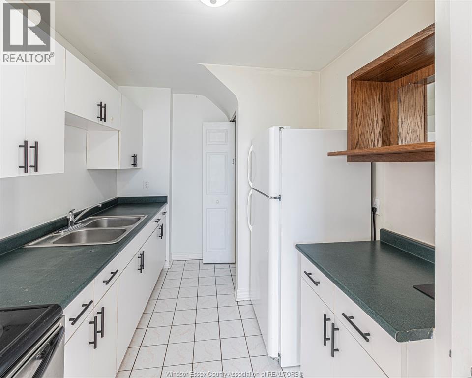 A kitchen with white cabinets and a black counter top.