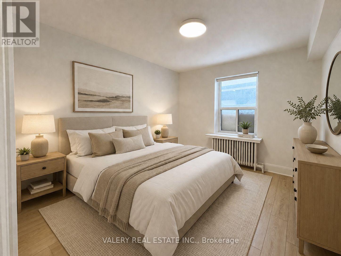 A bedroom with a large bed, nightstands, and a window.