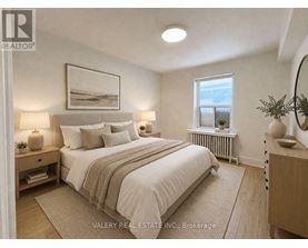 A bedroom with a large bed, nightstands, and a window.