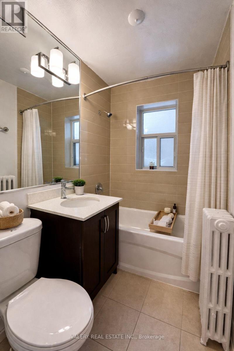 A bathroom with a toilet, sink, and bathtub.