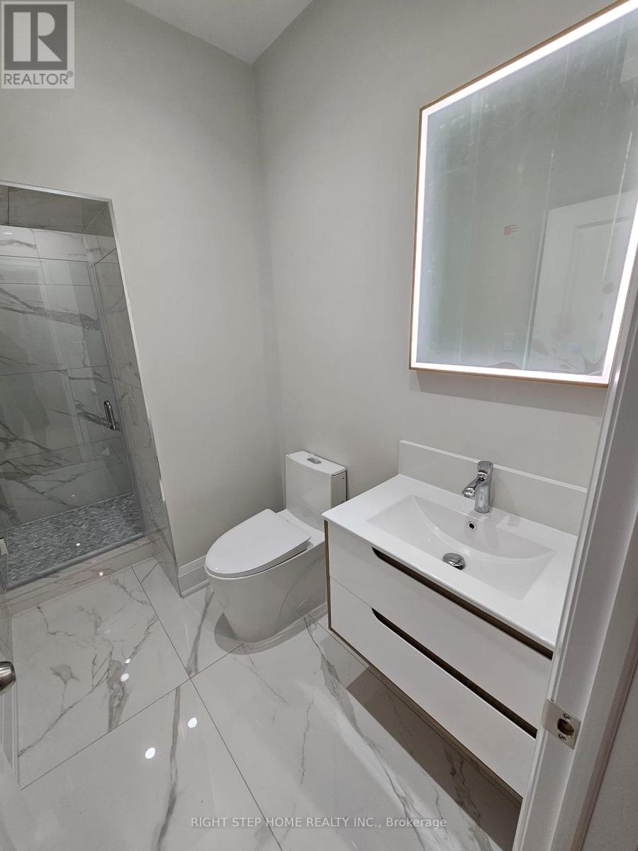 A white bathroom with a toilet, sink, and mirror.