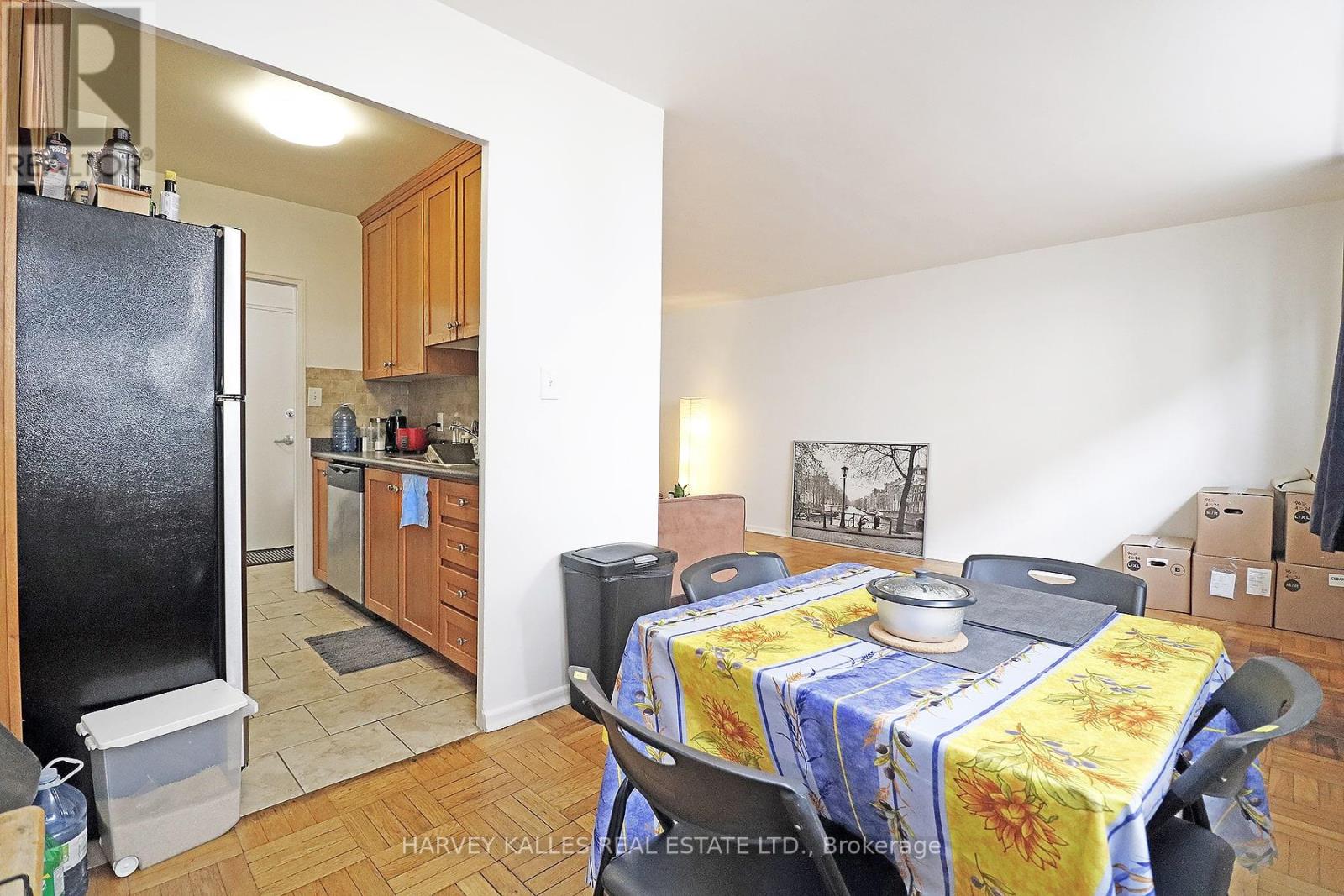 A kitchen with a refrigerator, table and chairs.