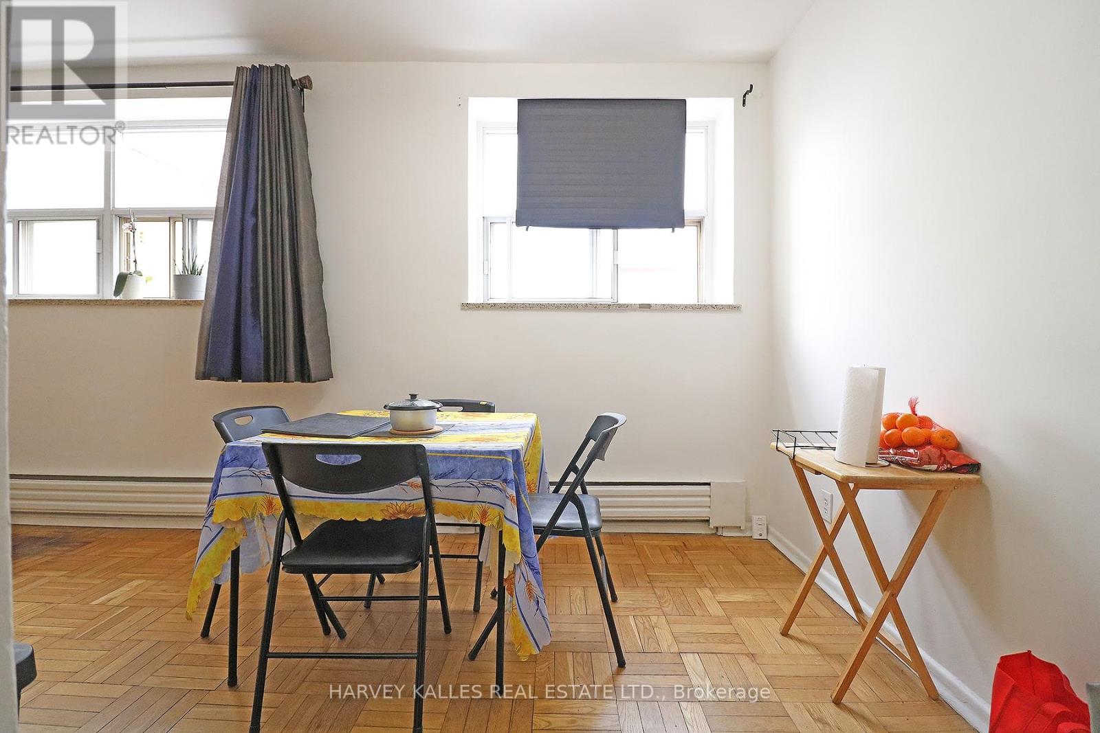 A dining room with a table set for two and a window with blinds.