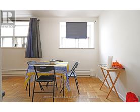 A dining room with a table set for two and a window with blinds.