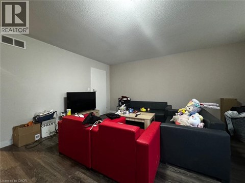 A living room with a red couch and a television.