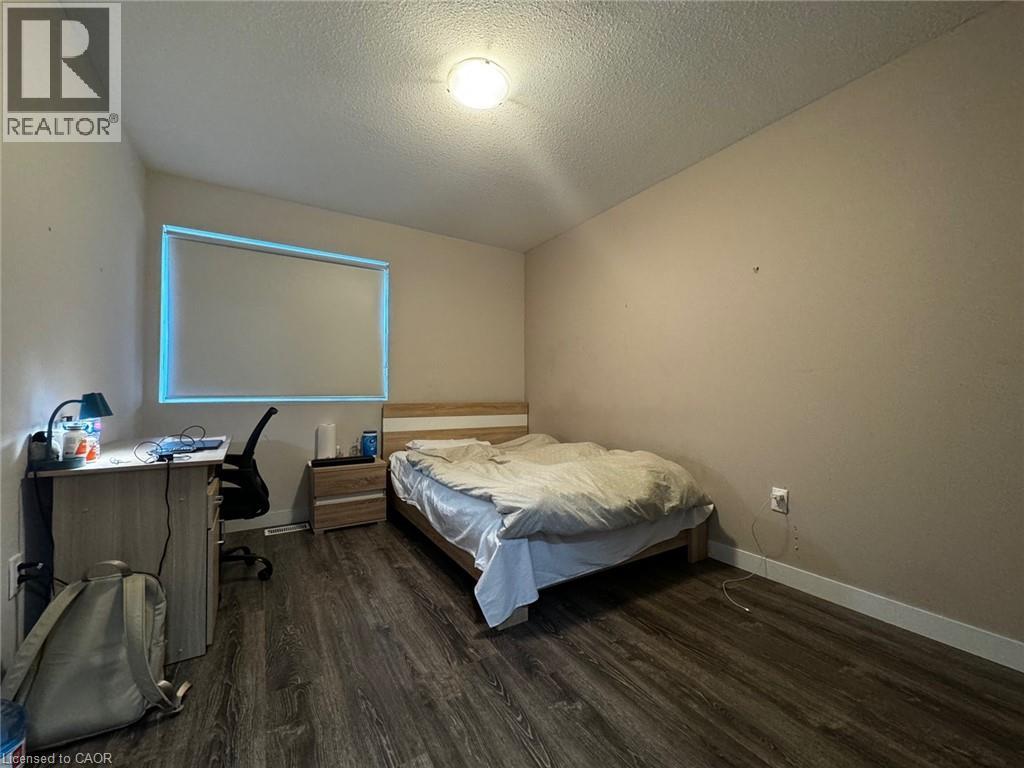 A bedroom with a bed, desk, chair, and window.