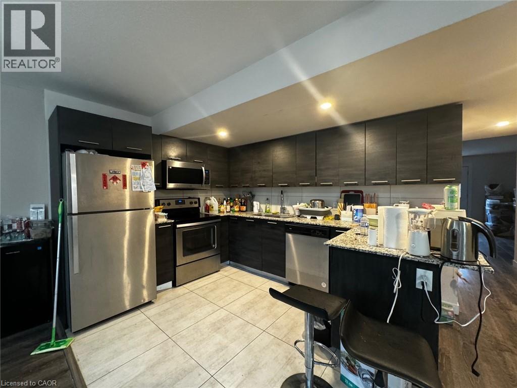 A modern kitchen with stainless steel appliances and black cabinets.