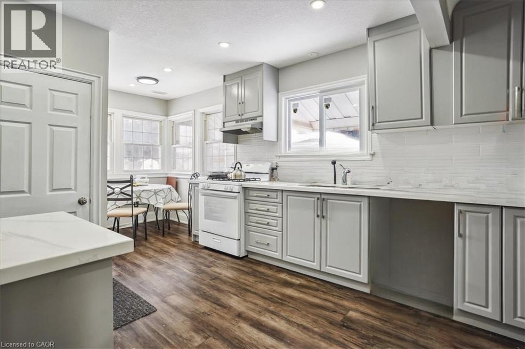 A kitchen with white cabinets and a wooden floor.