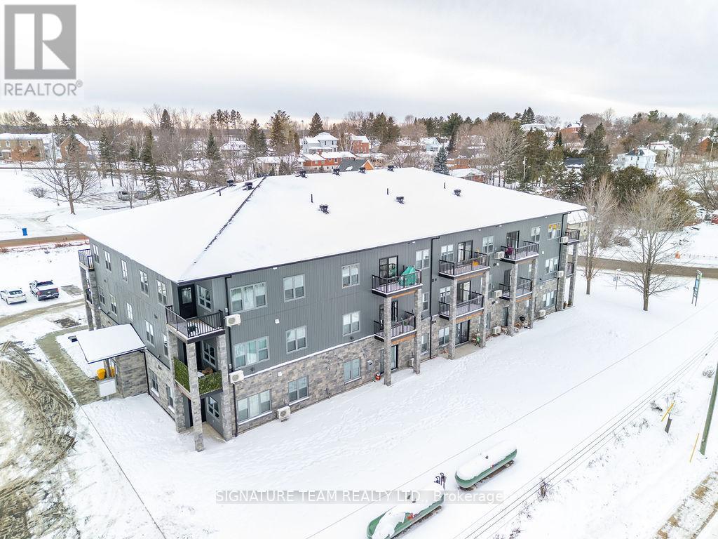 A large grey building with a snowy landscape in the foreground.