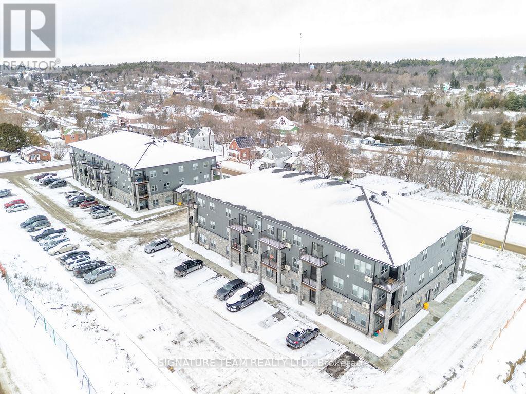 A snowy landscape with a building and cars parked in front.