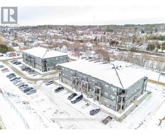 A snowy landscape with a building and cars parked in front.