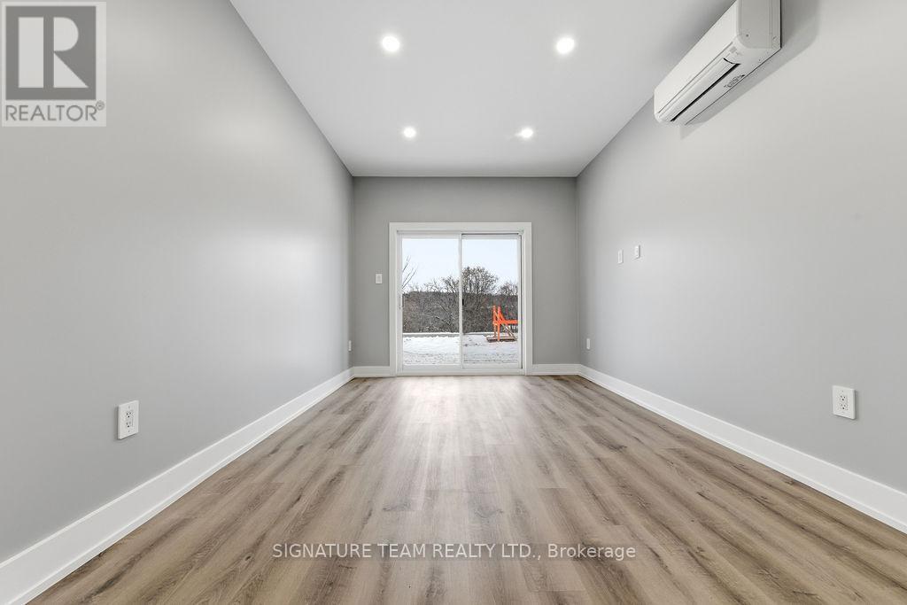 A spacious room with a view of a construction site through the window.