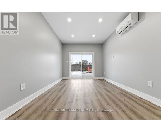 A spacious room with a view of a construction site through the window.