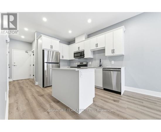 A modern kitchen with white cabinets and stainless steel appliances.