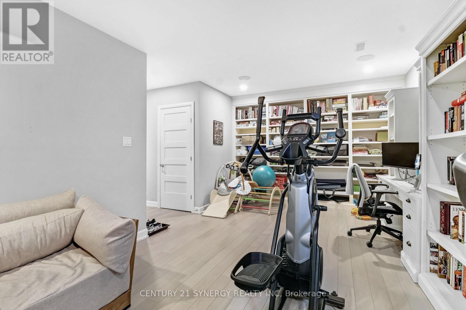 A home gym with a treadmill, exercise ball, and weights.