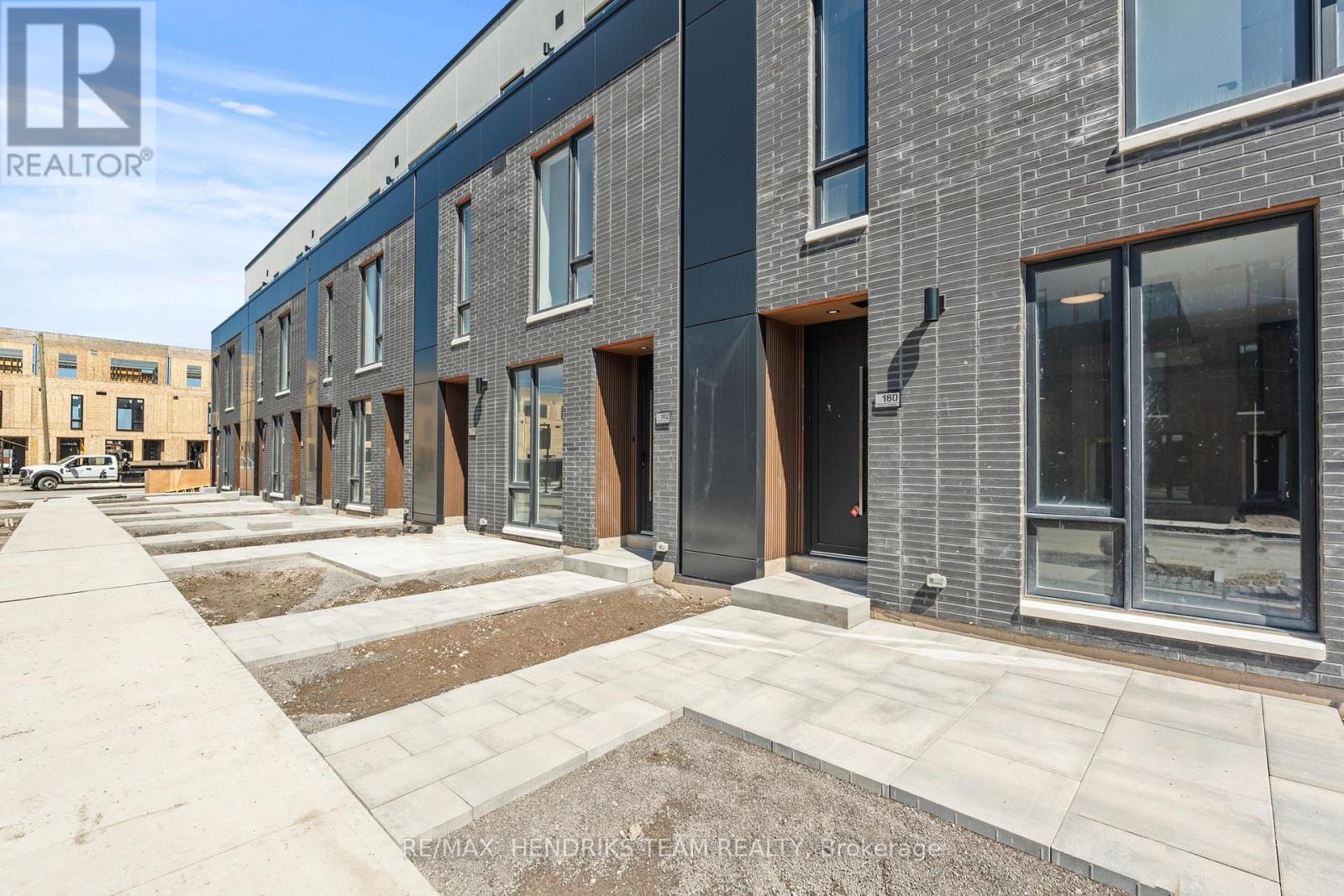 A row of new townhouses with a realtor logo in the corner.
